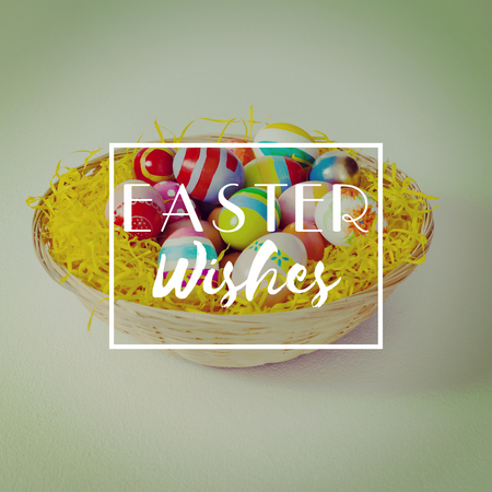 Easter greeting against painted easter eggs in the nestの写真素材