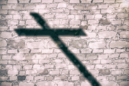 Close up of 3d wooden cross against brick wall backgroundの写真素材