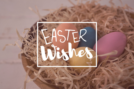 Easter greeting against colorful easter eggs in the nestの写真素材