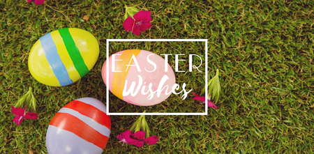 Easter greeting against painted easter egg on grass