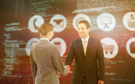 Smiling businessman shaking hands with colleague against composite image of blue codesの写真素材