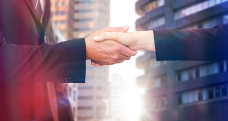Executives shaking hands against view of the city buildingsの写真素材