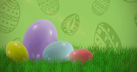 Big and small multi colored Easter eggs against green backgroundの写真素材