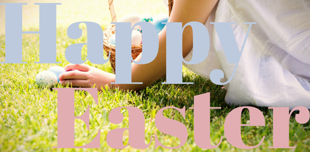 Little girl collecting easter eggs against happy easterの写真素材