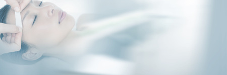 Close up view of hands waxing beautiful womans eyebrowの写真素材