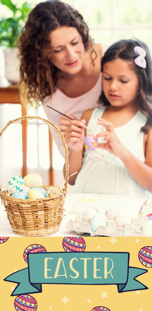 Happy mother and daughter painting easter eggsの写真素材