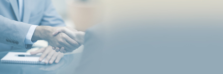 Two Businesspeople shaking hands indoorsの写真素材