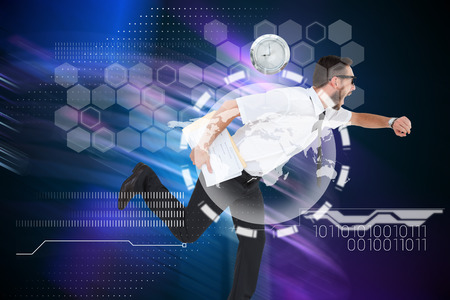 Geeky young businessman running late against purple light beams over skyscrapersの写真素材