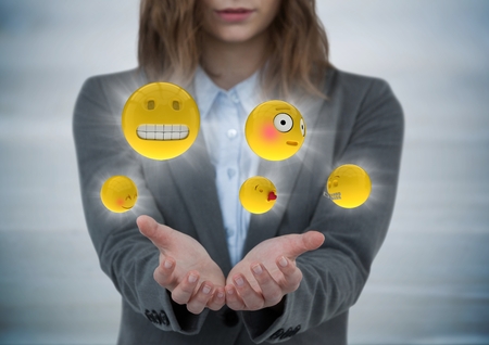 Digital composite of Business woman with hands out and emojis with flares against grey wood panelの写真素材