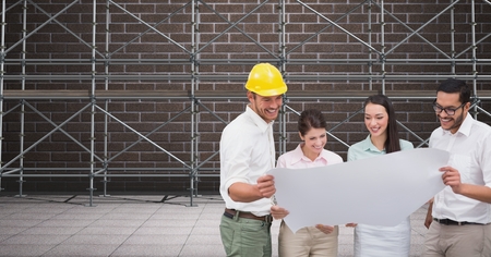 Digital composite of A group of architects looking a blueprint in front of 3D scaffoldingの写真素材