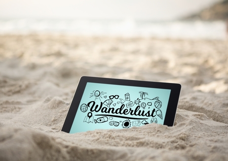 Digital composite of Tablet in sand with black wanderlust doodles against blue background
