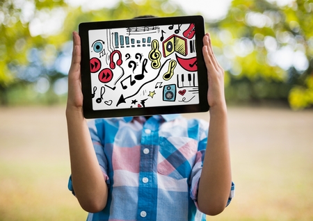 Digital composite of Kid holding tablet over face showing music doodles and white backgroundの写真素材