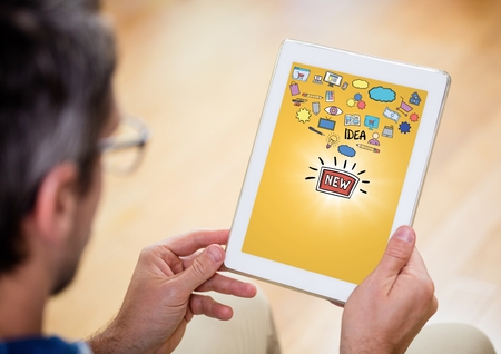 Digital composite of Person with tablet showing idea doodles with flare against yellow backgroundの写真素材