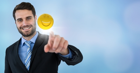 Digital composite of Business man touching emoji and flare against blue backgroundの写真素材