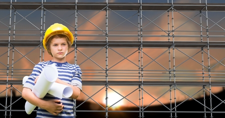 Digital composite of Boy with blueprints in front of 3D scaffoldingの写真素材