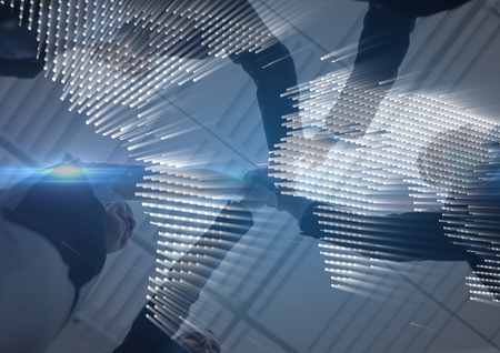 Digital composite of Business team putting hands together with blue map graphic overlay