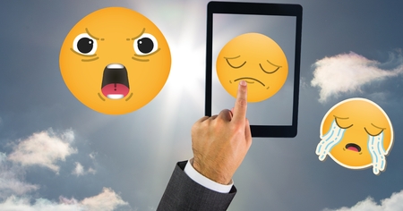 Digital composite of Businessman pointing at emojis in skyの写真素材