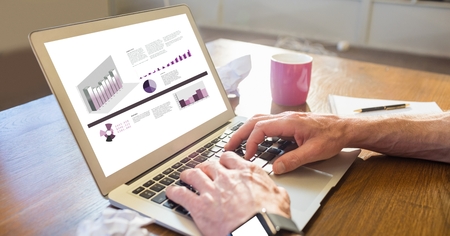 Digital composite of Businessman analyzing graphs on laptop at desk