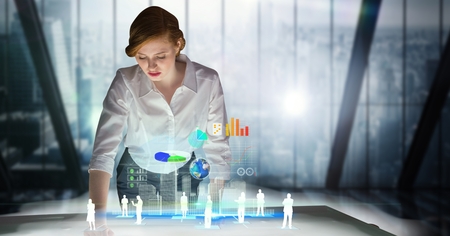 Digital composite of Businesswoman standing at futuristic deskの写真素材