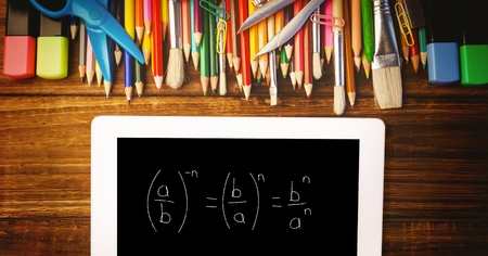 Digital composite of Overhead view of formula in digital tablet with color pencils and school...
