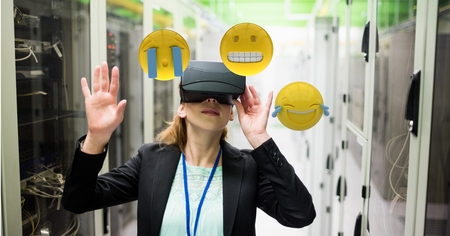 Digital composite of Woman looking at emojis through VR glasses