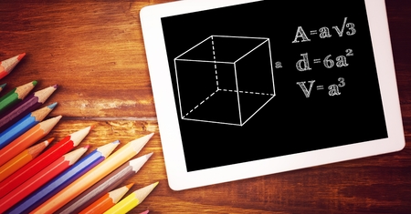 Digital composite of Directly above shot of formula in digital tablet with color pencils on wooden...