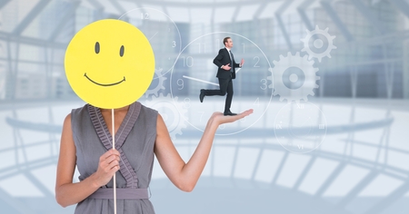 Digital composite of Digital composite image of businesswoman holding smiley while businessman running on her handの写真素材
