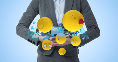 Digital composite of Digitally generated image of buisnesswoman with laptop and smiley face emoji against blue backgroundの写真素材