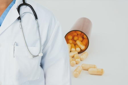Digital composite of Midsection of doctor with pill bottleの写真素材