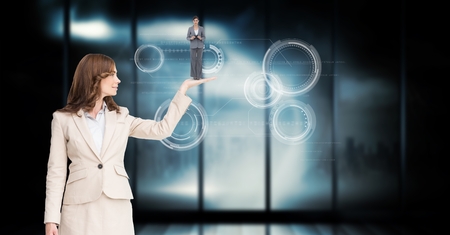 Digital composite of Businesswoman holding employee in palm over abstract backgroundの写真素材