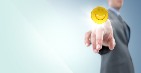Digital composite of Business man pointing at emoji with flare against blue backgroundの写真素材
