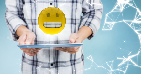 Digital composite of Man mid section with tablet, emoji, flare and network against blue backgroundの写真素材