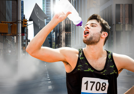 Digital composite of Male runner drinking on arrow shaped road on streetの写真素材