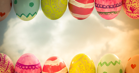 Digital composite of Easter eggs in front of cloudy skyの写真素材