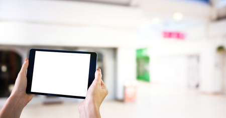 Digital composite of Hands with tablet in the shopping centre