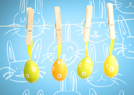 Digital composite of Easter Eggs on pegs in front of patternの写真素材