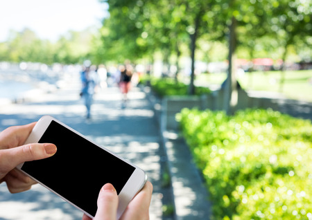 Digital composite of hands with phone in the park