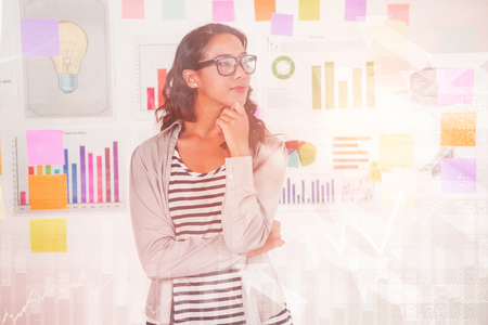 Stocks and shares against  pretty designer looking at postson glass window Pretty designer looking at postson glass windowin officeの写真素材