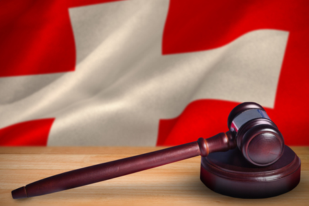 Hammer and gavel against 3d digitally generated swiss national flagの写真素材