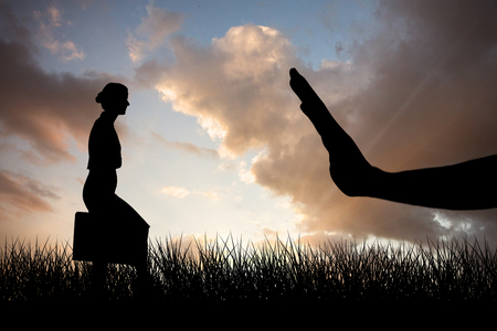 Businesswoman climbing with briefcase against blue and orange sky with cloudsの写真素材