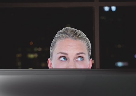 Digital composite of Business woman working in the office at nightの写真素材