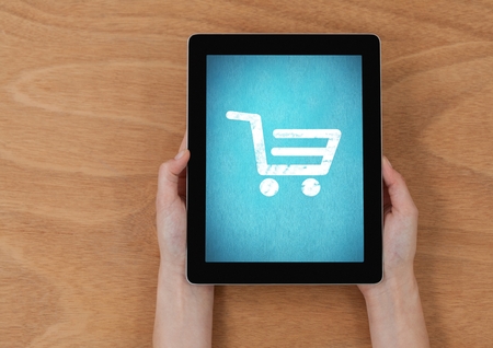 Digital composite of Person using Tablet with Shopping trolley iconの写真素材