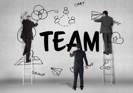 Digital composite of three men drawing a graphic about team on a wallの写真素材