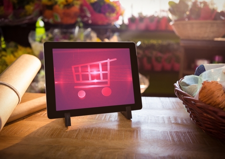 Digital composite of Tablet with Shopping trolley icon in Flower Shopの写真素材
