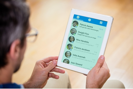 Digital composite of Man using an app message on tabletの写真素材
