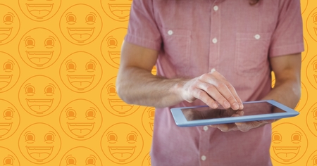 Digital composite of Man pink shirt mid section with tablet against yellow emoji patternの写真素材