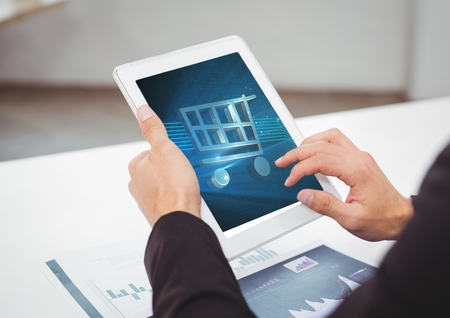 Digital composite of Person using Tablet with Shopping trolley icon