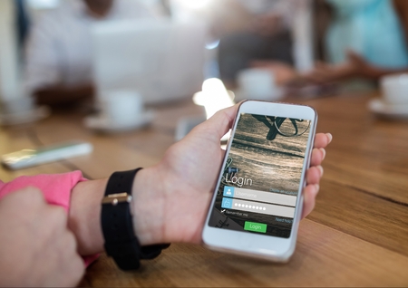 Digital composite of hand with watch and phone with login screen in a cafeteriaの写真素材