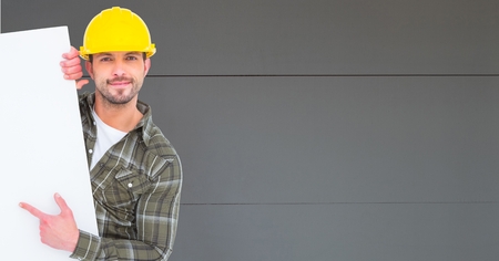 Digital composite of Worker wearing hardhat while pointing at blank bill board