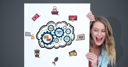 Digital composite of Smiling woman looking at various icons on billboard against gray backgroundの写真素材